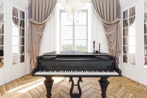 Baby Grand Piano standing in a parlor room in front of a great big window with sunlight beaming in.