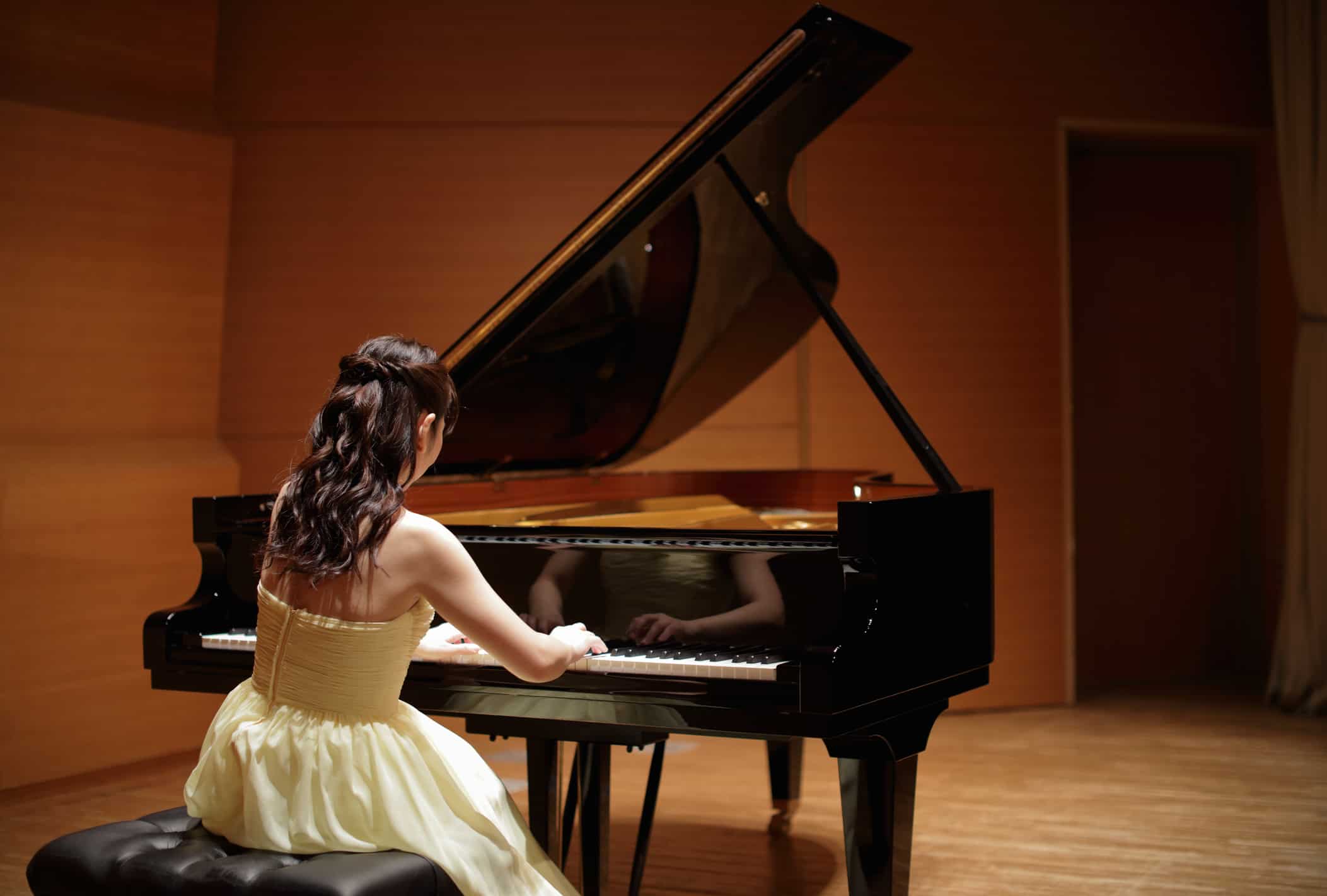 Female student playing piano during engaging piano recital