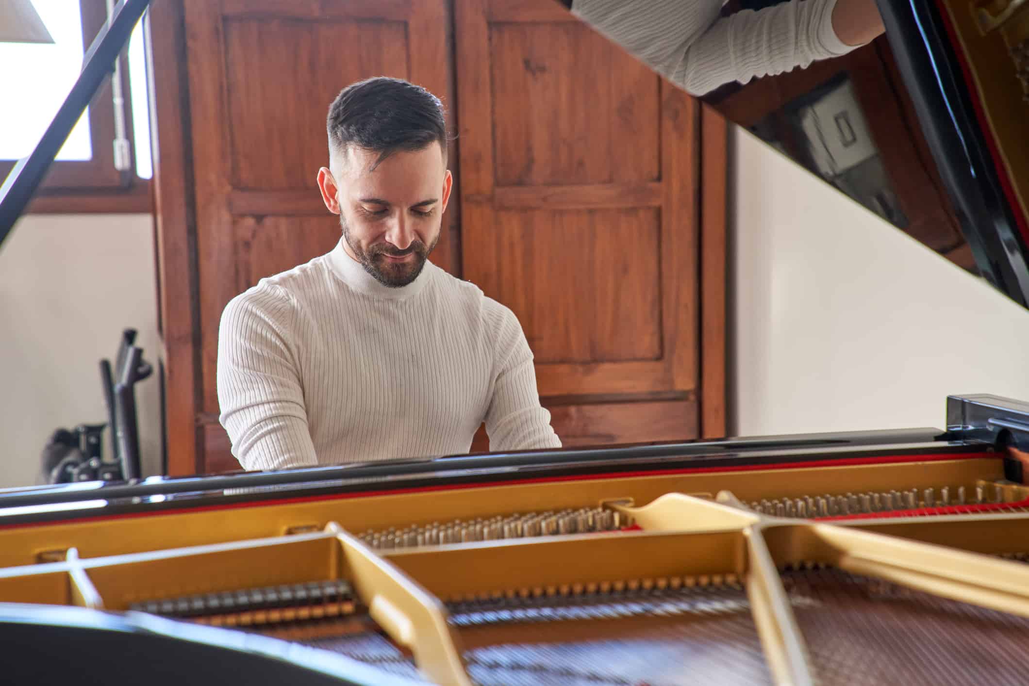 Young Adult Playing Grand Piano At Home